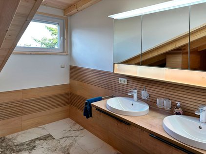 Das geräumige, helle Badezimmer ist mit zwei Waschbecken ausgestattet